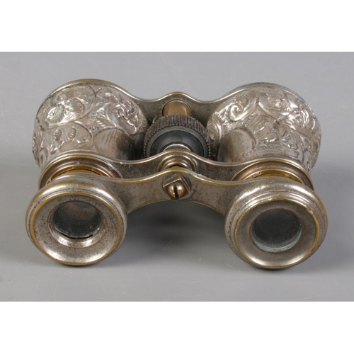 511 - A pair of Victorian silver bodied opera glasses, with embossed decoration. Assayed for Birmingham, 1... 