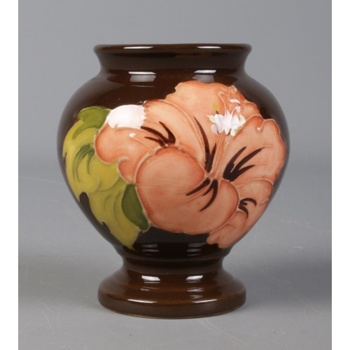 514 - A Moorcroft pottery brown ground baluster vase featuring coral hibiscus. 9.5cm tall.