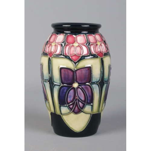 518 - A Moorcroft pottery 'Violet' vase, designed by Sally Tuffin. 11cm high, marks to the base.