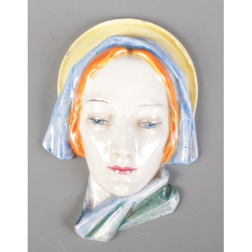 520 - An Art Deco porcelain face plaque. Impressed 976 to the back.