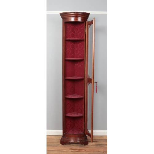 533 - A slender convex mahogany and glass fronted display unit, with key and upholstered interior. 204cm t... 