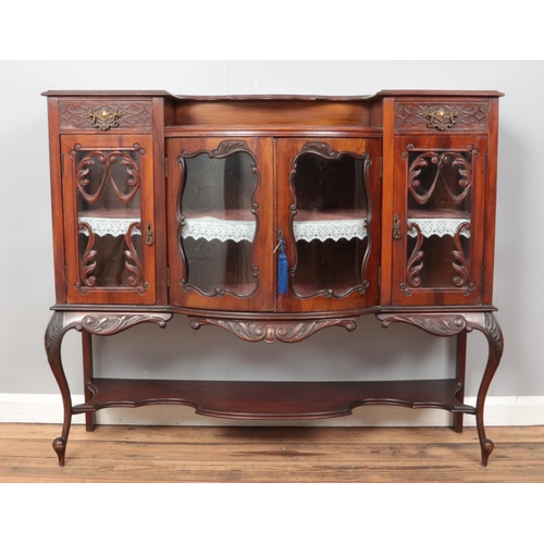 537 - A carved mahogany breakfront side cabinet, with central cabinet flanked by two cupboard doors and up... 