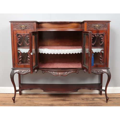 537 - A carved mahogany breakfront side cabinet, with central cabinet flanked by two cupboard doors and up... 