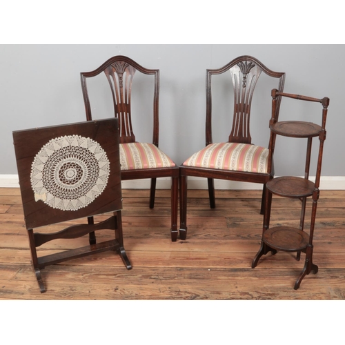 538 - A pair of mahogany dining chairs along with a folding cake stand and metamorphic table/fire screen.