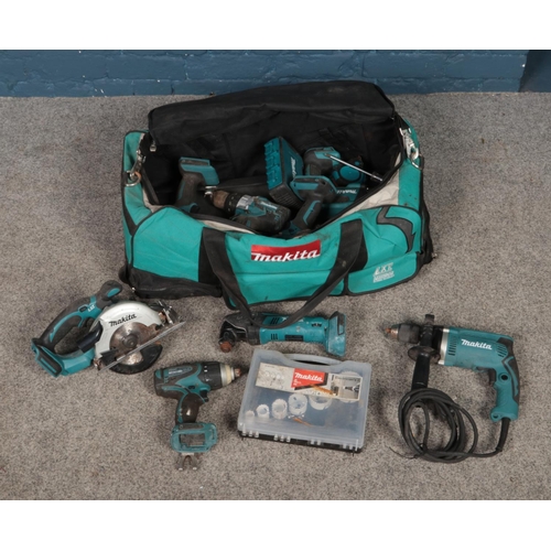 327 - A large bag of Makita tools including cordless drills, drill bits, saw, battery packs, etc.