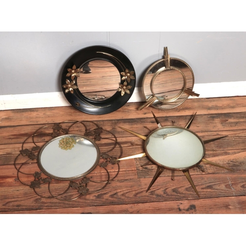 372 - Four decorative circular mirrors including sunburst and floral examples.