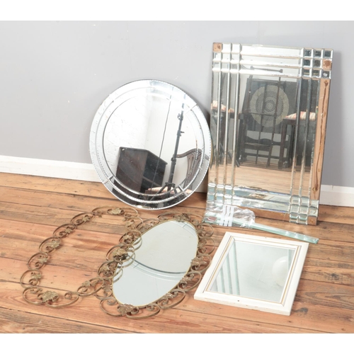 376 - A quantity of mirrors to include circular and floral framed examples.