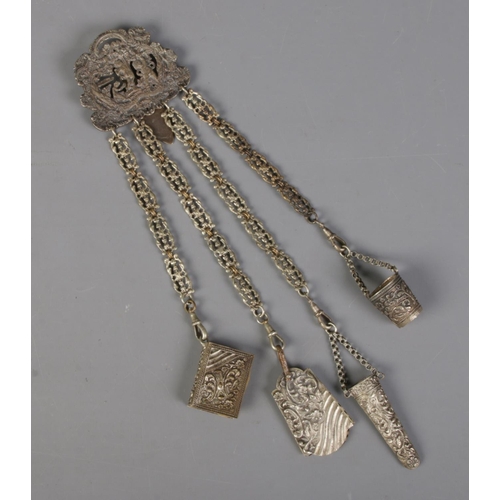 421 - An antique white metal chatelaine. Comprising of small bucket, scissors case, notebook with ivorine ... 