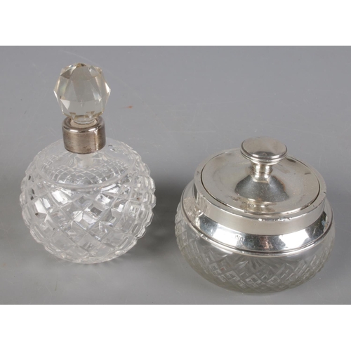 498 - A cut glass jar with silver lid and rim along with a cut glass silver collared scent bottle.