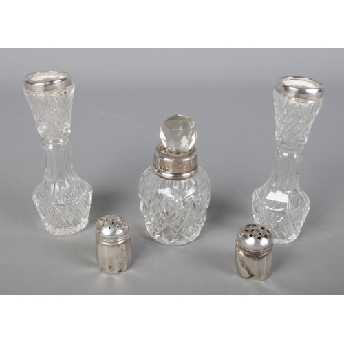 504 - A pair of silver pepperettes along with a pair of cut glass silver rimmed vases and a silver collare... 