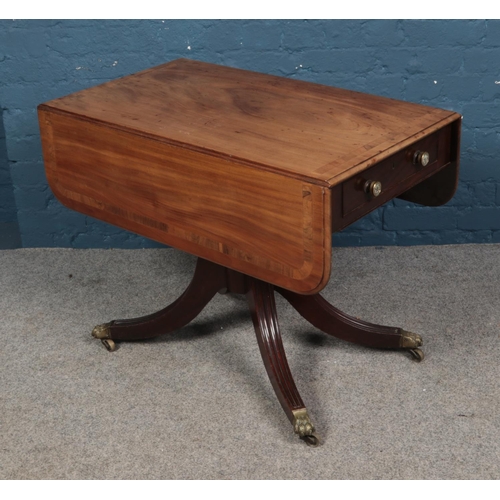 631 - A Regency mahogany Pembroke table with single drawer. Raised on reeded splayed legs with brass lion ... 