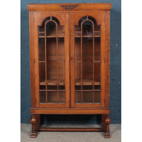 610 - A carved oak cabinet with glazed doors.