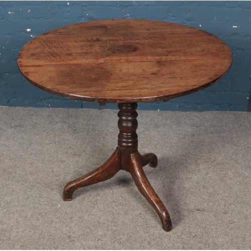 623 - A circular oak snap top table.