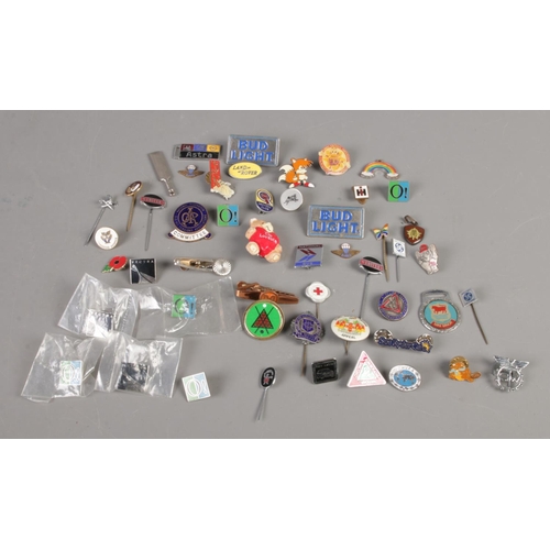 103 - A collection of assorted badges and charms, including enamel examples.