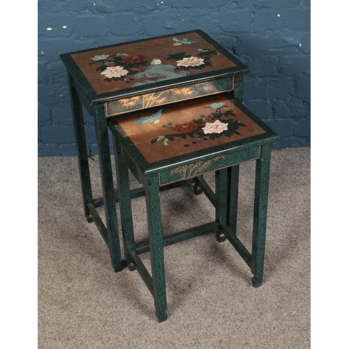 640 - An oriental themed set of nesting tables featuring painted floral scene.