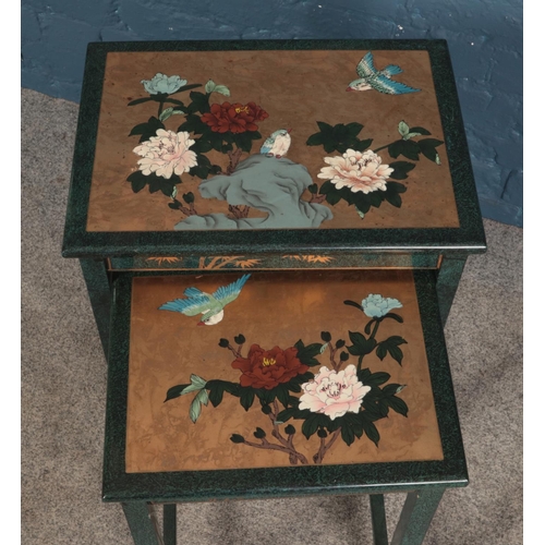 640 - An oriental themed set of nesting tables featuring painted floral scene.