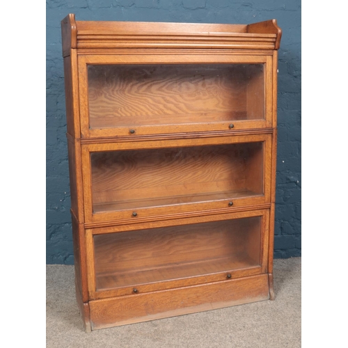 643 - A Globe Wernicke style oak three tier stacking bookcase with gallery top. (125cm x 87cm x 27cm)