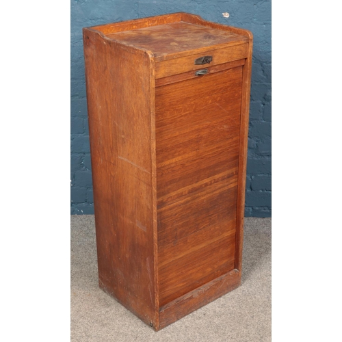 645 - An oak tambour front filing cabinet. (102cm x 43cm)