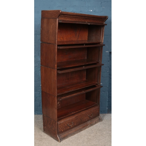 646 - A Globe Wernicke style oak four tier stacking bookcase with drawer base. (162xm x 87cm x 34cm)