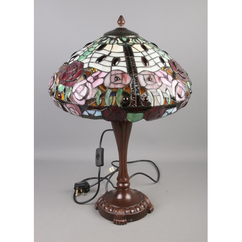 115 - A Tiffany style table lamp featuring rose floral decoration.