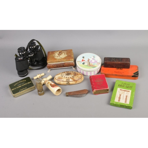 35 - A quantity of collectables to include corkscrews, vintage tins, binoculars, etc.