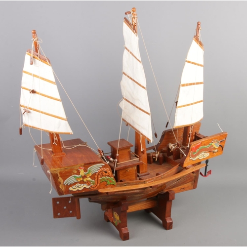 47 - A wooden model of a ship with oriental decoration. (60cm x 60cm)