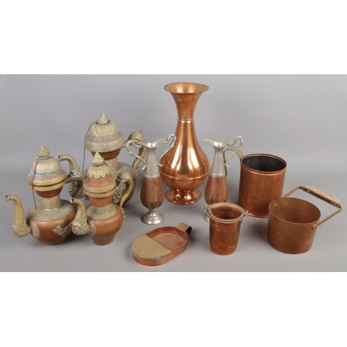 61 - A quantity of copper. Including three graduated teapots, measure, vase, etc.