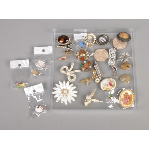 65 - A collection of costume jewellery brooches and pin badges.