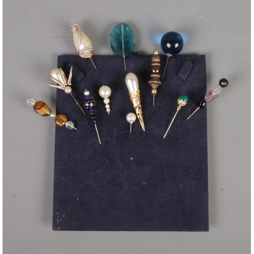 73 - A quantity of vintage hat pins including simulated pearl and gemstone examples.
