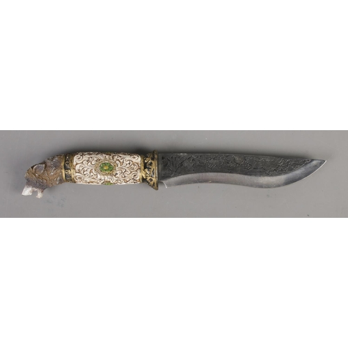88 - A hunting knife featuring etched and carved Wolf decoration with stand.