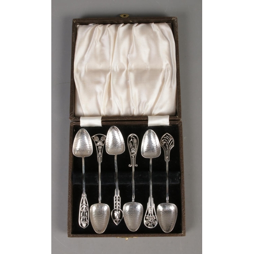 576 - A cased set of James Linton silver arts and crafts coffee spoons depicting various Australian flora.