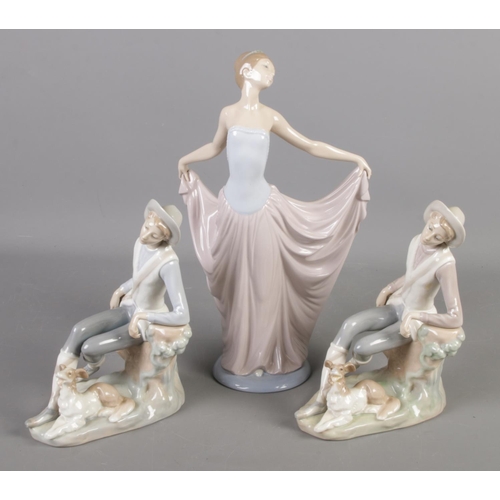 579 - Three Lladro figures. Includes dancing girl and two similar figures modelled as a boy with a dog.