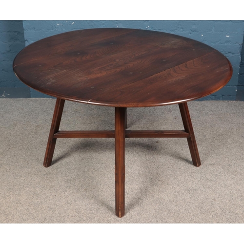 585 - An Ercol dark elm drop leaf dining table, with central cross stretcher. Height: 72cm, Width: 113cm, ... 