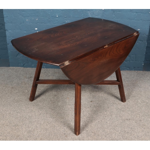 585 - An Ercol dark elm drop leaf dining table, with central cross stretcher. Height: 72cm, Width: 113cm, ... 