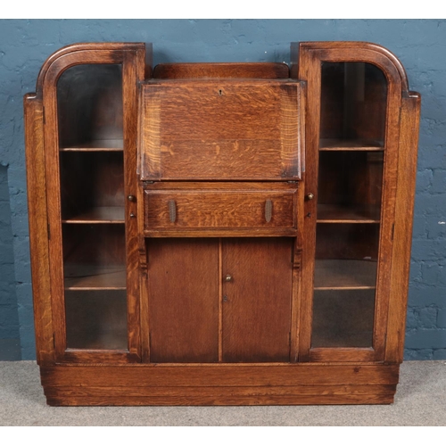 594 - An oak 'side by side' bureau, with central writing desk flanked by two glass fronted cupboards. Heig... 