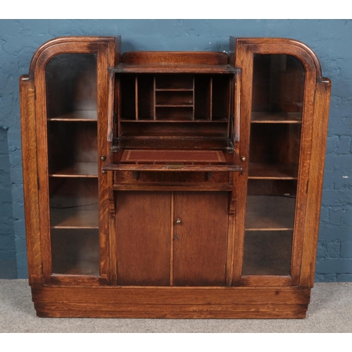 594 - An oak 'side by side' bureau, with central writing desk flanked by two glass fronted cupboards. Heig... 