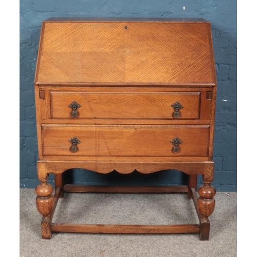 595 - A 1930s oak bureau with quarter veneered front.