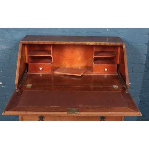 595 - A 1930s oak bureau with quarter veneered front.