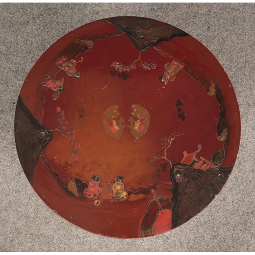 596 - A small Japanese lacquered table set on three feet. The top decorated with two birds to the centre, ... 