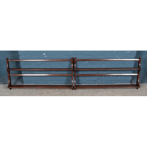 598 - A pair of Ercol dark elm hanging wall racks. 97cm wide.