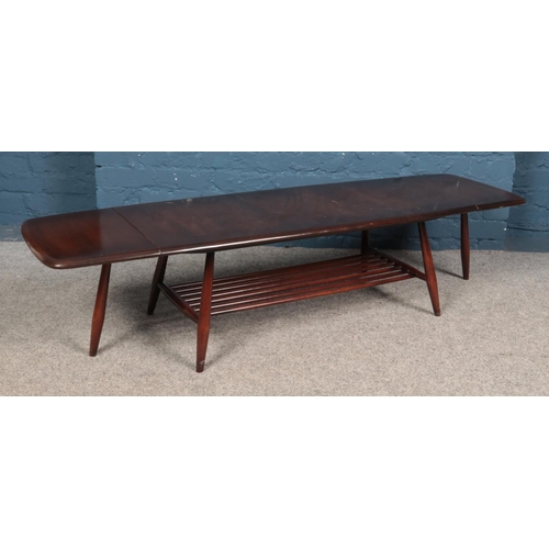 600 - An Ercol dark elm extending coffee table, with rectangular top and drop down leaves to each side. He... 