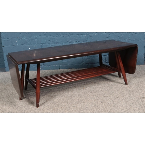 600 - An Ercol dark elm extending coffee table, with rectangular top and drop down leaves to each side. He... 