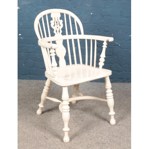 604 - A Victorian white painted Windsor arm chair with crinoline stretcher.