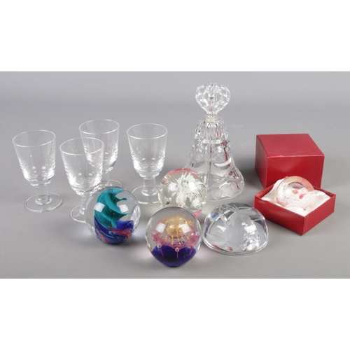 76 - A collection of glass. Includes Caithness paperweights, drinking glasses and a cut glass bell.