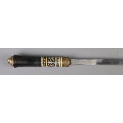 378 - An Indian ebony sword stick featuring carved bone decoration and tigers head on hilt.