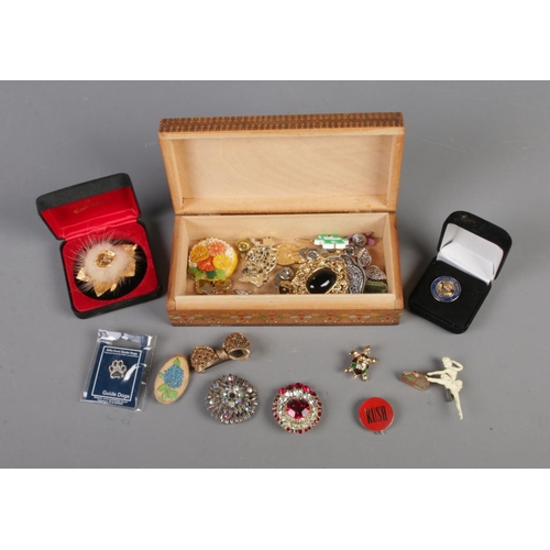 85 - A collection of assorted pin badges and brooches to include bow and floral examples.