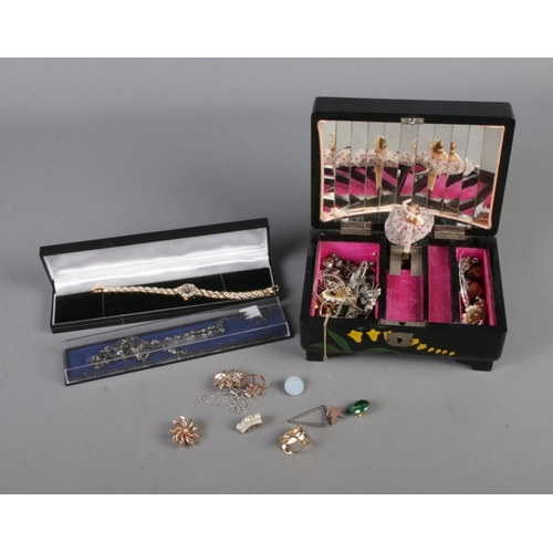 90 - A musical jewellery box with contents including assorted rings, bracelets, necklaces, etc.