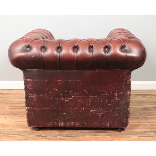 423 - An oxblood leather Chesterfield club arm chair.