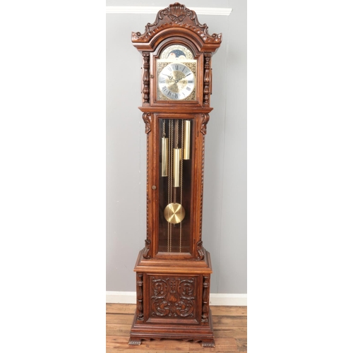 427 - A modern carved longcase clock featuring roman numeral face and triple weights. Approx. height 206.5... 