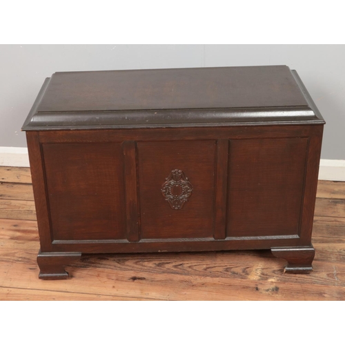 440 - A paneled blanket box featuring central carved motif.